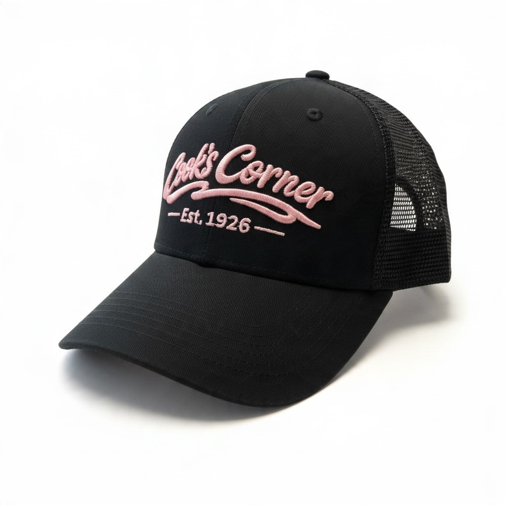 Cook's Corner black trucker hat with breathable mesh back and pink embroidered logo on the structured front panel.